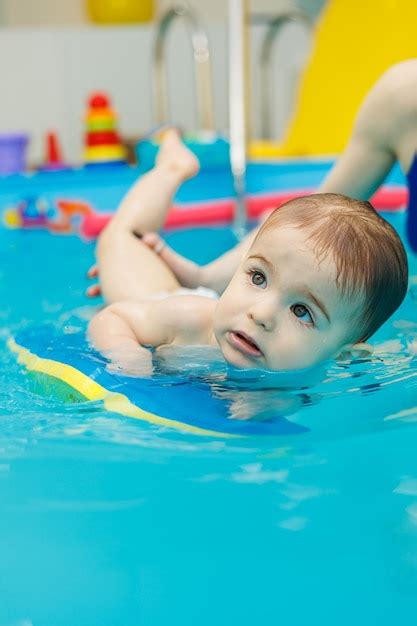 Um Menino De 2 Anos Aprende A Nadar Em Uma Piscina Um Treinador