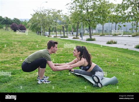 Personal Trainer Helping Young Woman Doing Splits And Stretching