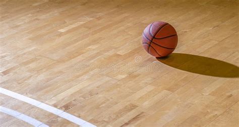 Basketball On Hardwood Court Floor With Natural Lighting Workout