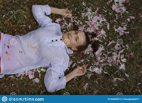 The Girl is Lying on the Grass, she Has Flower Petals in Her Hair Stock ...