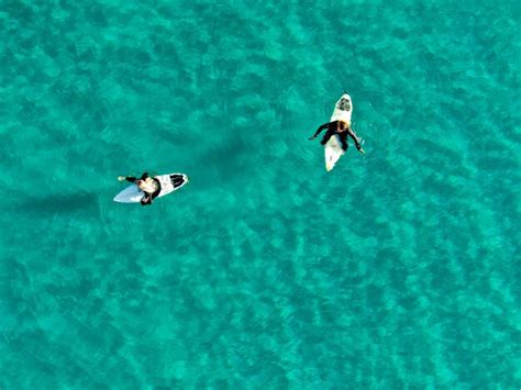 Premium Photo Two People On Surfboards In The Water With The Word Surf On The Bottom