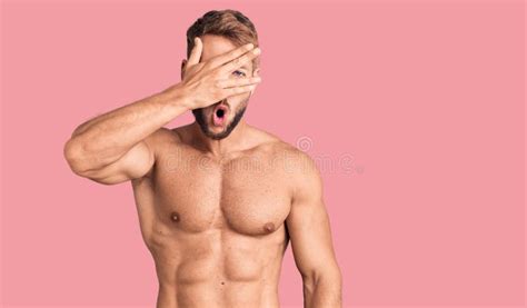 Young Caucasian Man Standing Shirtless Peeking In Shock Covering Face