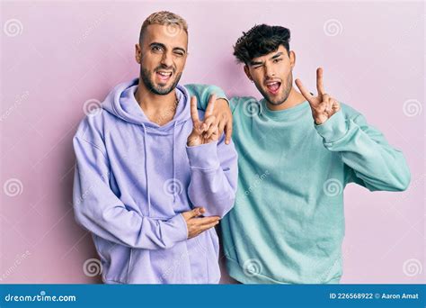 Homosexual Gay Couple Standing Together Wearing Casual Clothes Smiling With Happy Face Winking