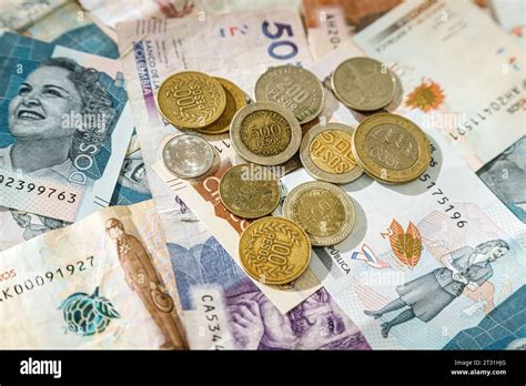 Macro closeup of Colombian peso coins on banknotes of different ...