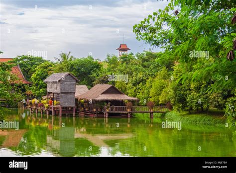 Une maison traditionnelle en bois sur pilotis Khmer reflétée par l eau