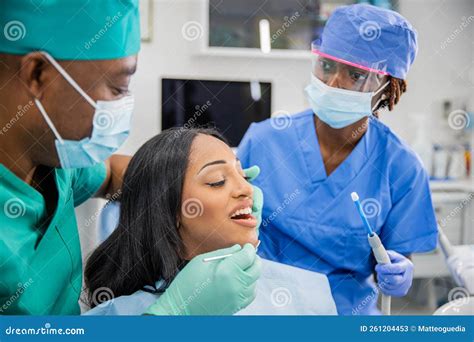 Girl with Open Mouth during a Dental Visit, Dentist and Assistant at ...