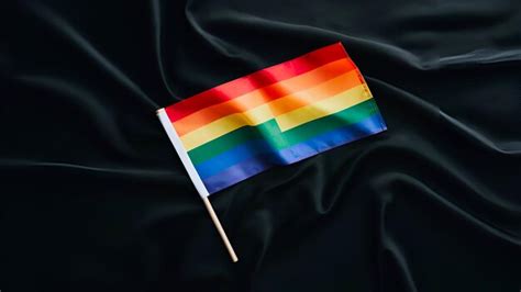 Una Mano Sosteniendo Una Peque A Bandera Del Orgullo Gay En Fondo Negro Imagen Premium