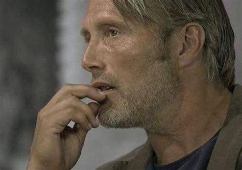 A Man With Grey Hair Is Holding His Hand To His Chin And Looking Off