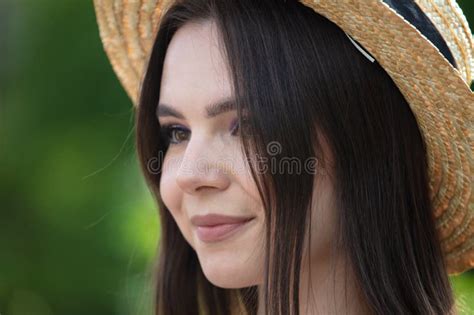 Portrait Of A Brunette Girl In A Straw Hat Outdoors In Summer Stock
