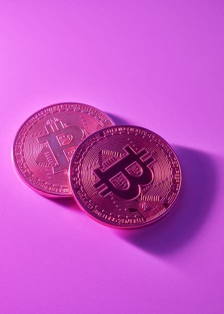 Dos bitcoins dorados aislados en primer plano de fondo rosa púrpura con