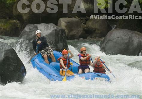 Three People Are Rafting Down A River With Rocks In The Background And