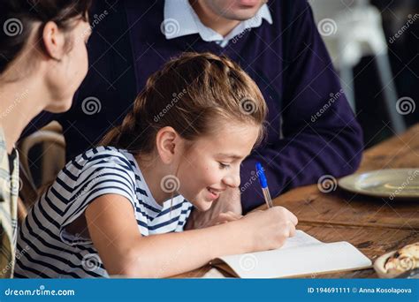 Une Fille Décrire Quelque Chose Dans Son Carnet Et Souriant Image