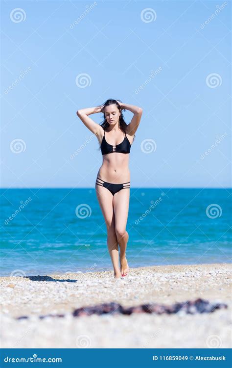 Attraktive Junge Frau Im Bikini Gehend Auf Pebble Beach Stockbild