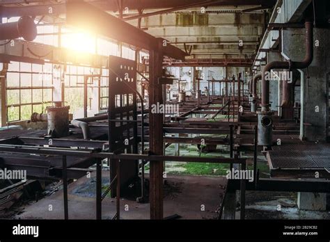 Old abandoned factory with rusty remains of industrial machinery in workshop Stock Photo - Alamy