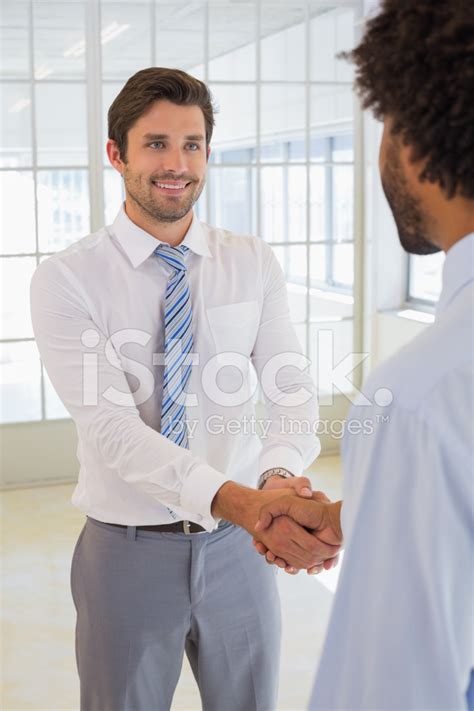 Smiling Businessmen Shaking Hands In Office Stock Photo | Royalty-Free ...