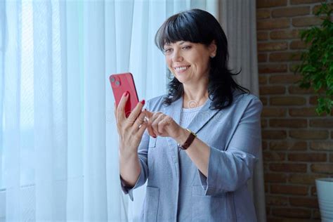 Mature Business Woman Using Smartphone Standing Near Window Stock Image Image Of Serenity