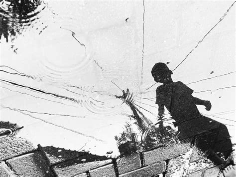 Reflection of a Children Playing in a Puddle of Rain Stock Photo ...