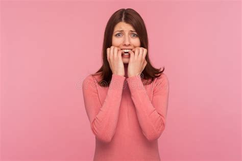 Nervous Confused Brunette Woman In Pink Sweater Biting Nails On Her Fingers In Panic Depression