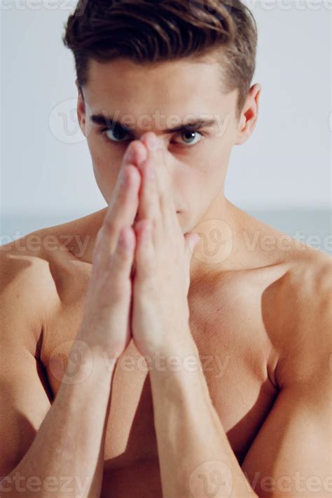 A Guy With A Naked Torso Joined His Hands Near The Face Of A Muscle Fitness Bodybuilder
