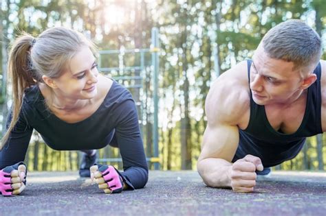 Premium Photo Sporty Couple Doing Exercise Plank Outdoors