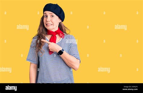 Junge Sch Ne Blonde Frau Tr Gt Franz Sisch Baskenm Tze Und Gestreiften T Shirt Zeigt Zur Seite