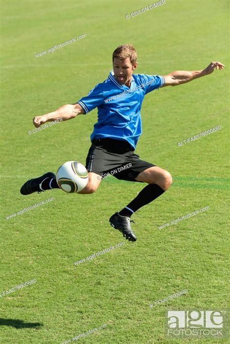 Soccer player kicking ball in midair, Stock Photo, Picture And Royalty ...