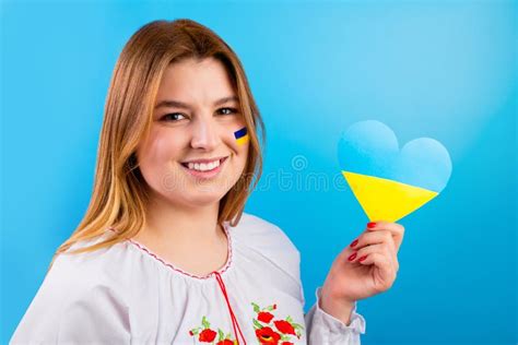 A Happy Young Ukrainian Girl With The Flag Of Ukraine On Her Face In An