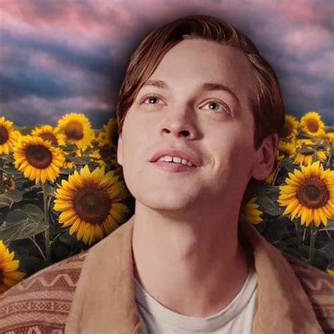 A Man Standing In Front Of A Field Of Sunflowers With His Eyes Closed