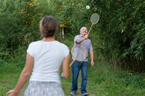 Premium Photo Mature Man And Girl Playing Badminton Outdoors