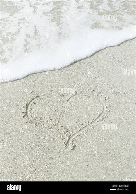 Couple Drawing Heart In Sand Hi Res Stock Photography And Images Alamy