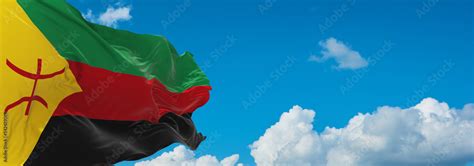 flag of Berbers Tuareg people at cloudy sky background, panoramic view ...