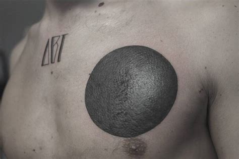 Blackwork circle tattoo on the left side of the chest.