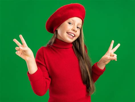 Joyeuse Petite Fille Blonde Portant Un Béret Rouge Regardant à L avant Montrant Un Signe De Paix