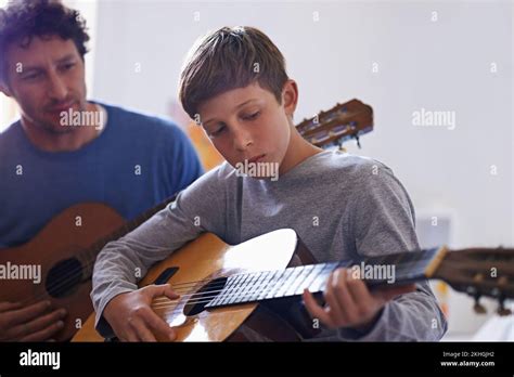 Transmitir las habilidades un niño aprendiendo a tocar la guitarra de