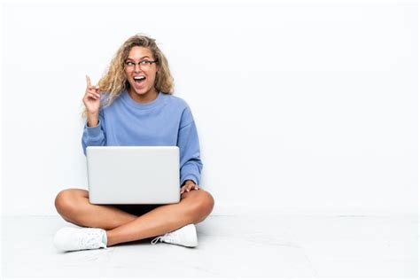 Menina de cabelo encaracolado um laptop sentada no chão a