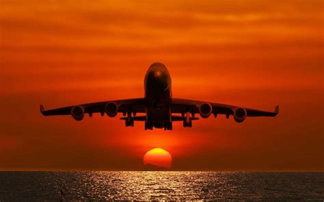 Passagiersvliegtuig Boven De Zee Bij Zonsondergang Fotobehang