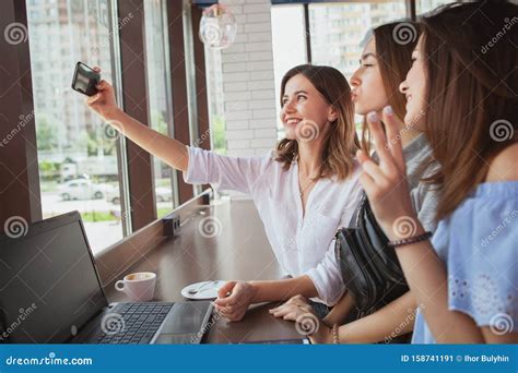 Beautiful Female Friends Enjoying Morning Coffee At The Cafe Together