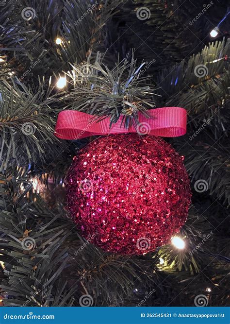 Red Christmas Ball With Christmas Ribbon On Christmas Tree Close Up