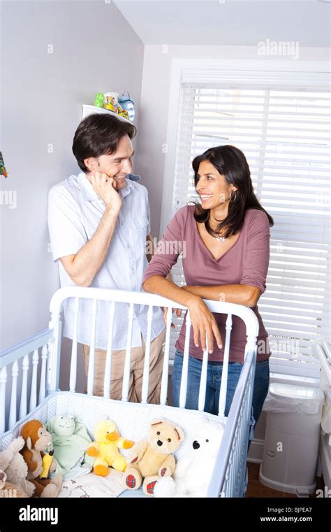 Married Couple Leaning On Baby Crib Stock Photo Alamy