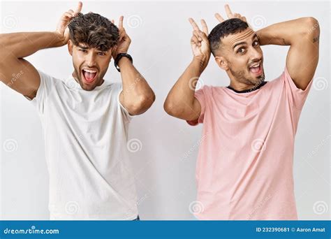 Joven Pareja Gay Parado En Un Contexto Aislado Posando Divertido Y Loco Con Los Dedos En La