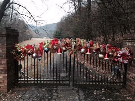 A Gate With Wreaths And Christmas Decorations Hanging On It S Sides In