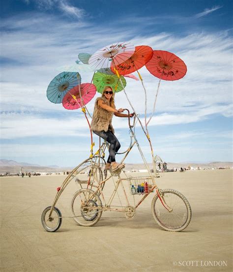 A Woman Rides A Modified Bike With Multicolored Parasols At Burning Man