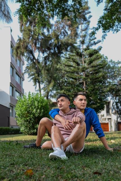 Una pareja gay sentada distraída en un parque Foto Premium
