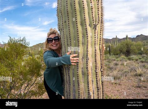 Ditzy Blonde Woman Gives A Saguaro Cactus A Hug Stock Photo Alamy