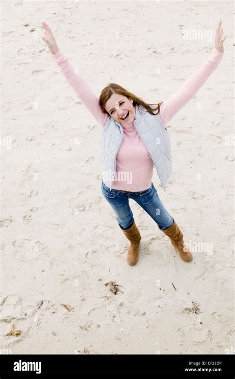 View From Above Of Female Long Blonde Hair Wearing Pink Poloneck Jumper And Blue Jeans Tucked