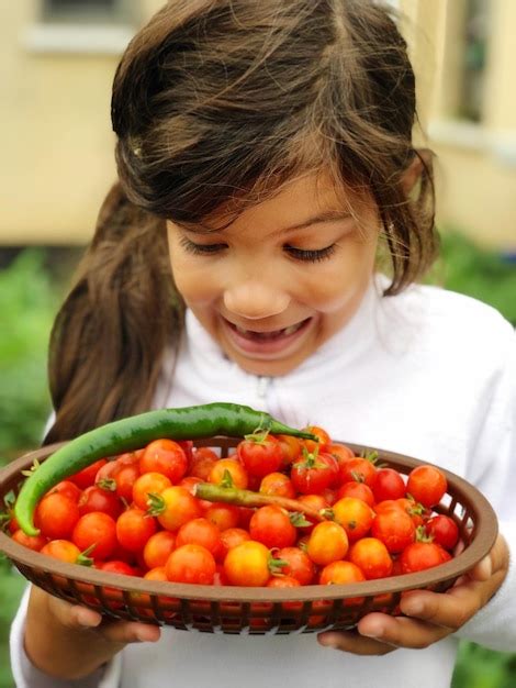 Premium Photo Cute Girl Holding Fruits In Plate Homegrown Tomatoes