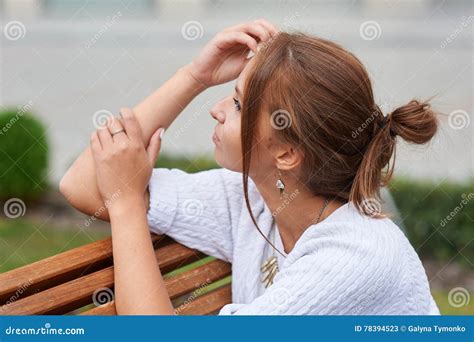 A Jovem Mulher Bonita Senta Se Em Um Banco No Parque Do Ver O Imagem De