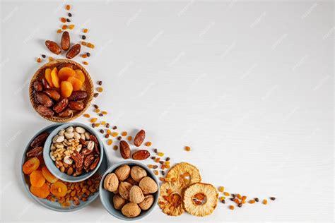 Premium Photo Mixed Nuts And Dried Fruits On A Plate On A White