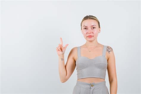 La Belle Fille Blonde Lève Son Index Sur Fond Blanc Photo Gratuite
