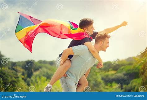 Jóvenes Felices Familia Gay Con Bandera Arco Iris De Lgbt Volando Divirtiéndose Al Aire Libre